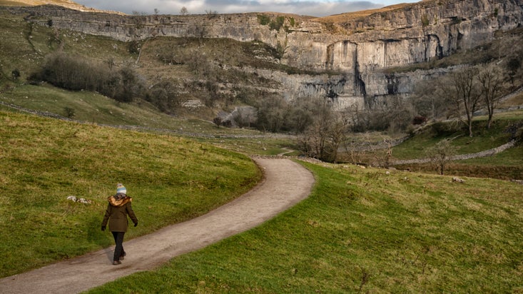 A walker on the footpath to Malham Cove
